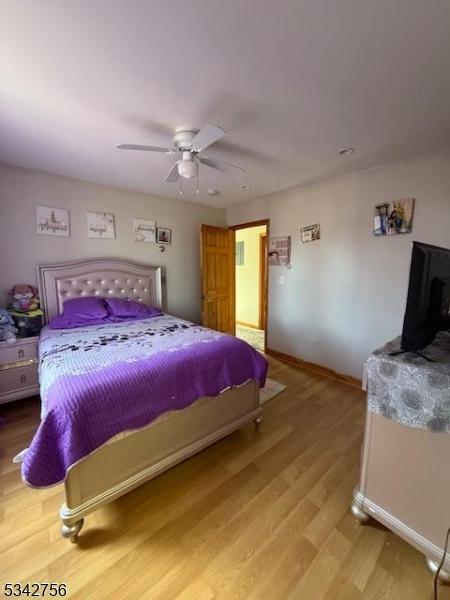 bedroom featuring a ceiling fan, wood finished floors, and baseboards