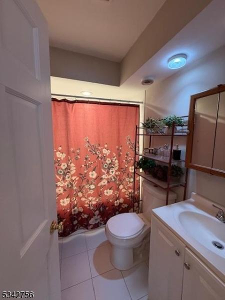 full bathroom with tile patterned floors, a shower with shower curtain, toilet, and vanity