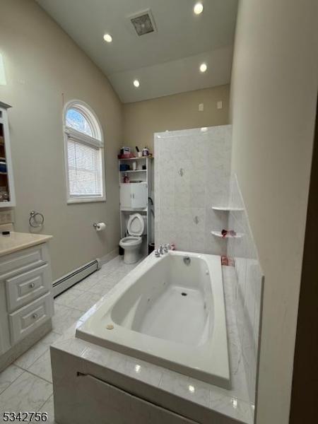 full bath with visible vents, toilet, a baseboard radiator, a whirlpool tub, and vaulted ceiling