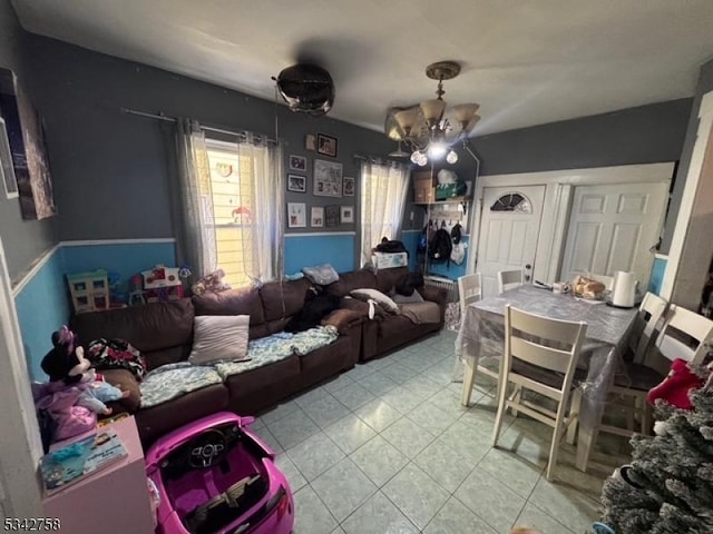 living room with tile patterned floors and a notable chandelier