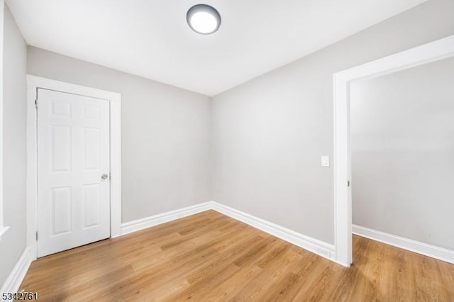 spare room featuring light wood-style floors and baseboards