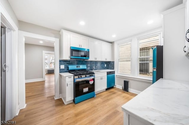 kitchen with tasteful backsplash, gas stove, freestanding refrigerator, white cabinets, and dishwasher