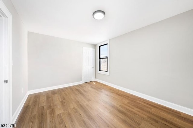 unfurnished room with light wood-type flooring and baseboards