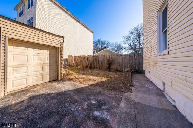 view of home's exterior with a garage and fence