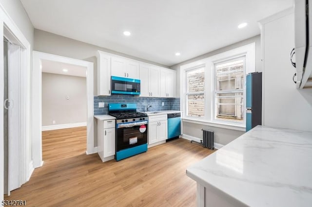 kitchen featuring freestanding refrigerator, white cabinets, dishwasher, and gas stove