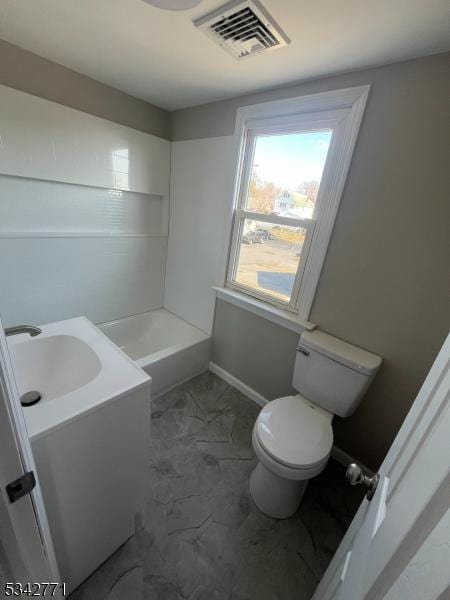 bathroom with visible vents, toilet, a bathing tub, marble finish floor, and vanity