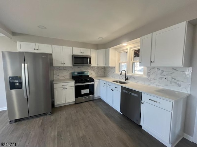 kitchen with dark wood-style floors, stainless steel appliances, a sink, and white cabinetry