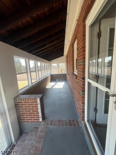 exterior space with lofted ceiling with beams and wood ceiling