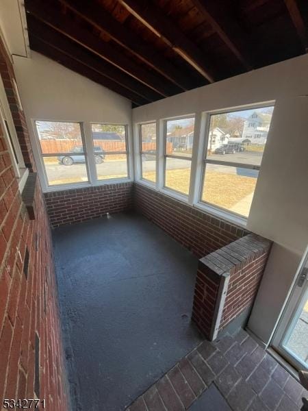 unfurnished sunroom featuring vaulted ceiling