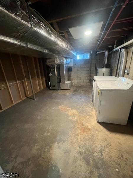 unfinished below grade area with heating unit, water heater, and washing machine and clothes dryer