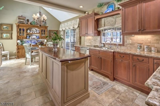 kitchen featuring a wealth of natural light, backsplash, an inviting chandelier, and vaulted ceiling