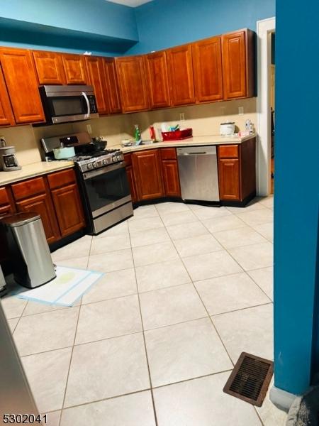 kitchen featuring visible vents, stainless steel appliances, light countertops, and light tile patterned flooring