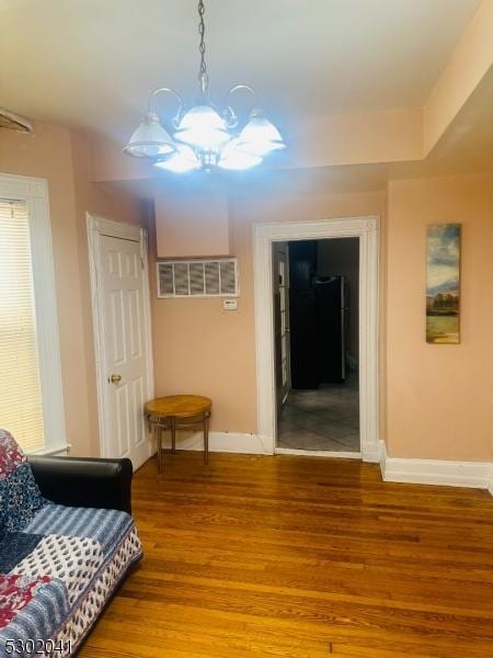 interior space featuring light wood finished floors, baseboards, and a chandelier