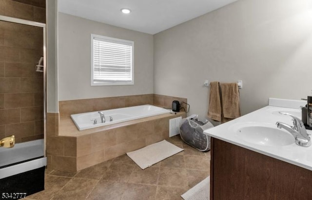 bathroom featuring tile patterned flooring, a garden tub, a sink, and a shower stall