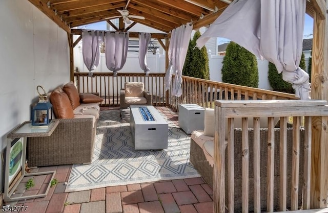 view of patio featuring ceiling fan, an outdoor living space, and a gazebo