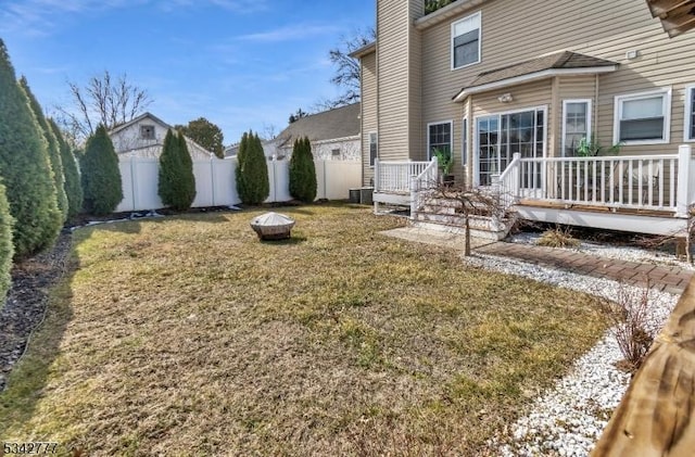 view of yard with an outdoor fire pit, a fenced backyard, central AC, and a wooden deck