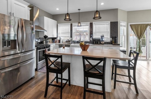 kitchen with a healthy amount of sunlight, light wood-style floors, appliances with stainless steel finishes, and light countertops