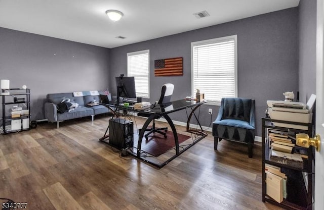 office area with baseboards, visible vents, and wood finished floors