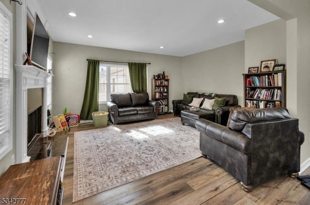 living area featuring recessed lighting, a fireplace, and wood finished floors