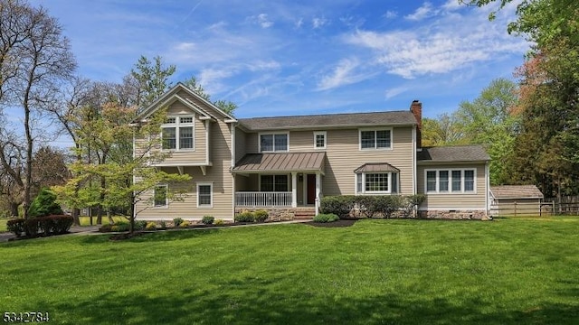 view of front of home with a front lawn, covered porch, and a chimney
