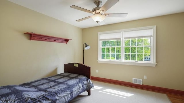 carpeted bedroom featuring baseboards and ceiling fan