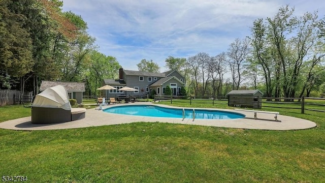 view of swimming pool featuring a shed, a patio area, and an outdoor structure