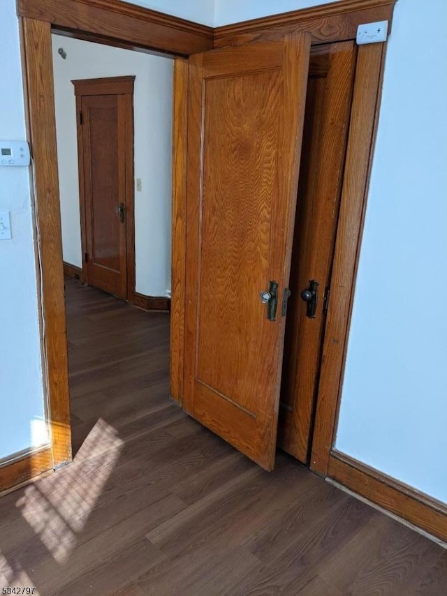 hallway with wood finished floors and baseboards