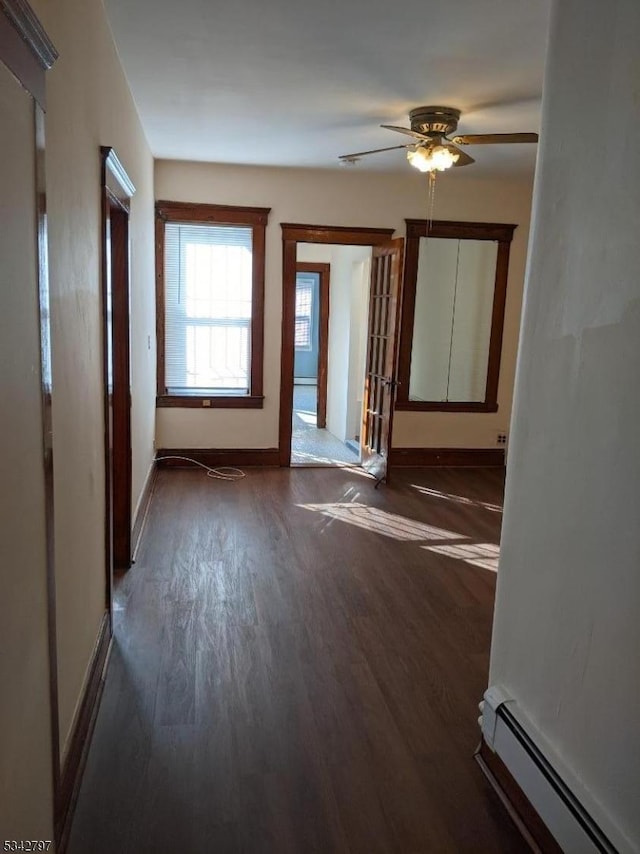 interior space with a ceiling fan, wood finished floors, baseboards, and a baseboard radiator