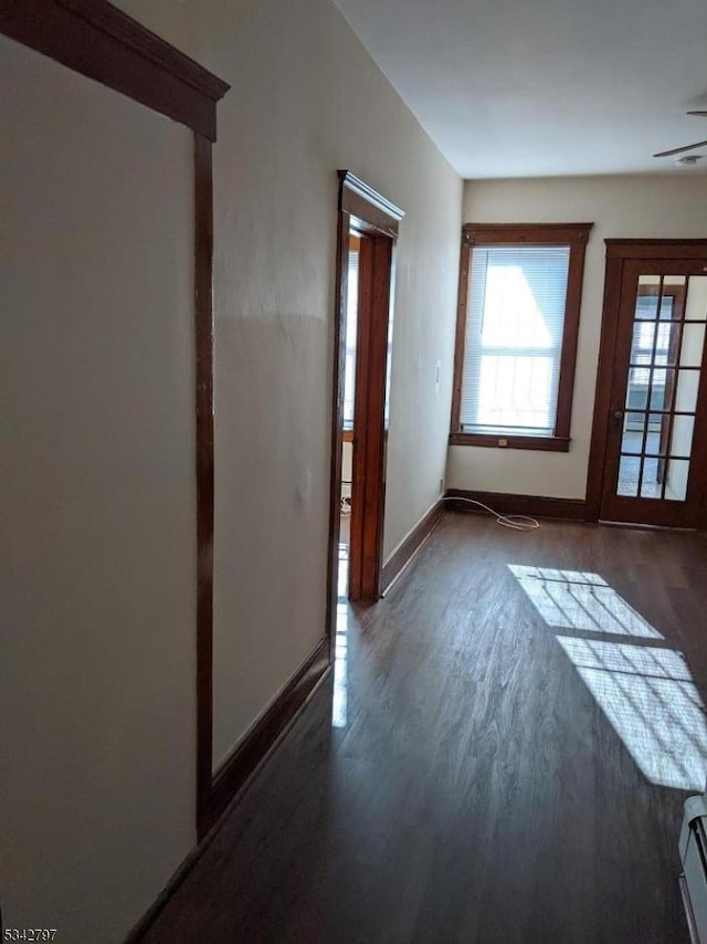 interior space featuring baseboards and dark wood-style flooring