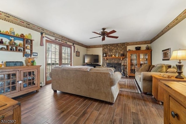 living area featuring ceiling fan, a fireplace, and dark wood finished floors