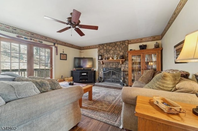 living area with dark wood-style flooring, a fireplace, and ceiling fan