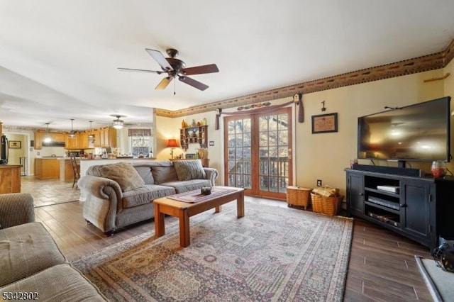 living area featuring french doors, a ceiling fan, and wood tiled floor