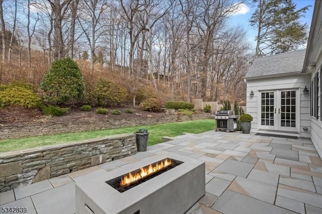 view of patio with area for grilling, french doors, and an outdoor fire pit