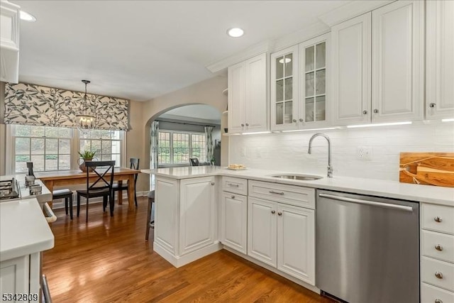 kitchen featuring dishwasher, white cabinetry, light countertops, and a sink