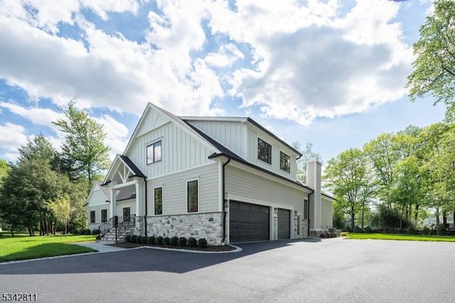 28 Old Forge Dr, Warren Twp, NJ 07059 - view of side of home with an attached garage, stone siding, board and batten siding, and asphalt driveway