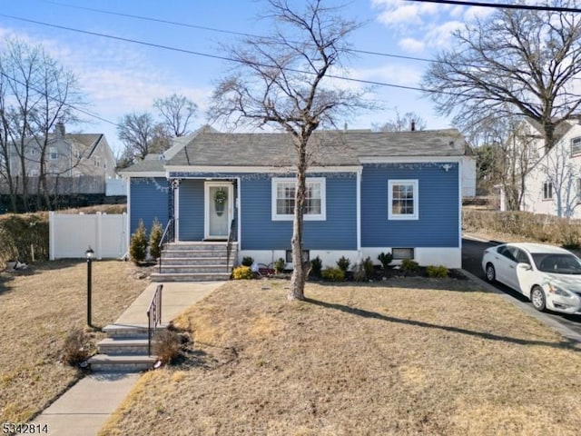 view of front facade featuring a front lawn and fence