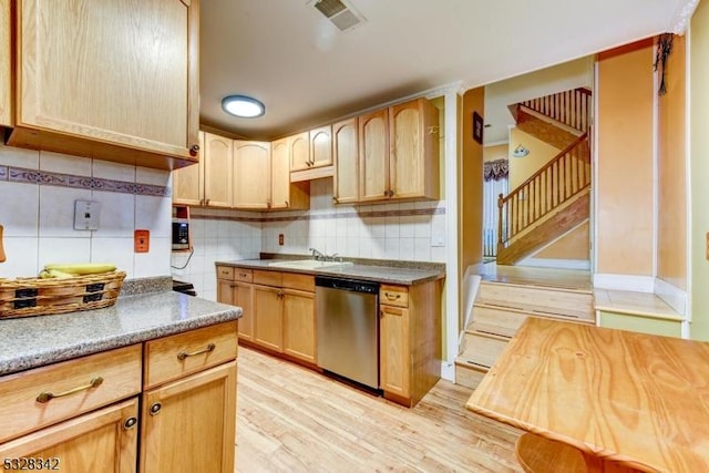 kitchen with stainless steel dishwasher, backsplash, a sink, and light wood-style flooring