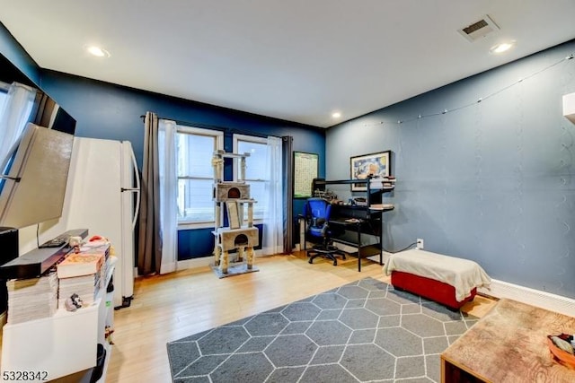 interior space featuring baseboards, visible vents, wood finished floors, and recessed lighting