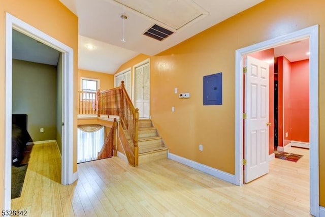 interior space with electric panel, visible vents, baseboards, and wood finished floors