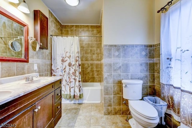 bathroom featuring a sink, toilet, tile walls, and tile patterned floors