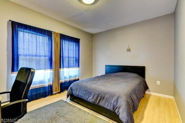 bedroom featuring baseboards and wood finished floors