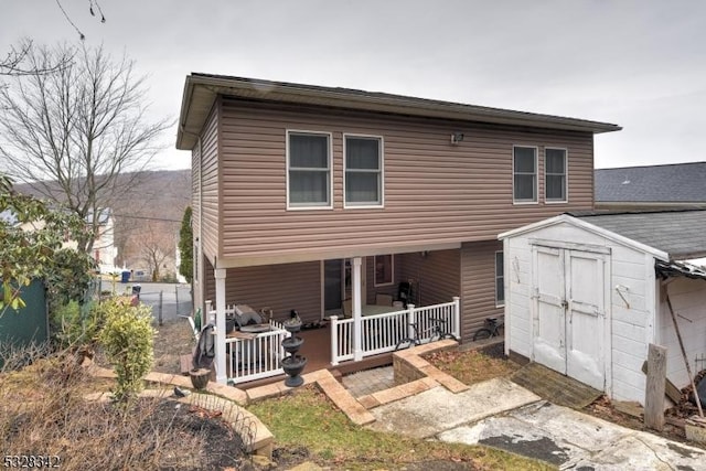 rear view of property featuring a storage shed, an outbuilding, and fence