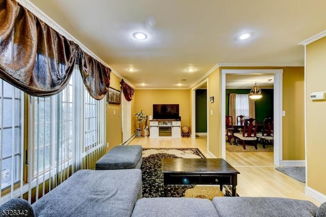 living room featuring ornamental molding, recessed lighting, baseboards, and wood finished floors