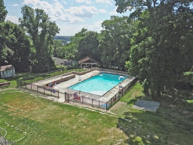 view of pool featuring a lawn, fence, and a fenced in pool