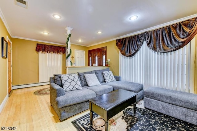 living area featuring a baseboard heating unit, ornamental molding, wood finished floors, and visible vents