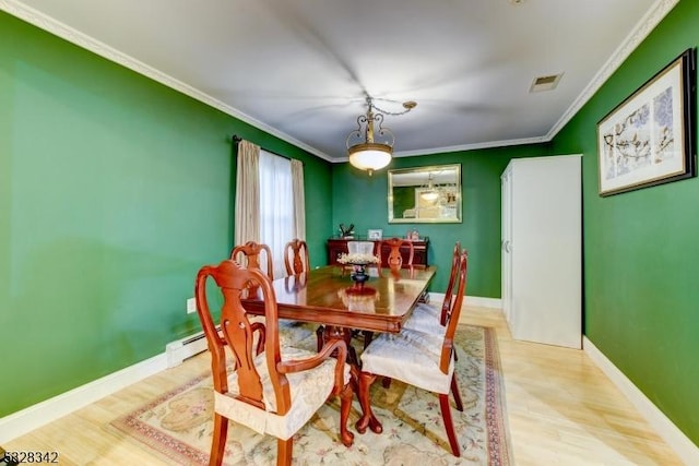 dining space with ornamental molding, wood finished floors, and visible vents