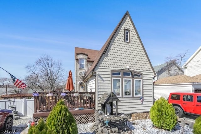 rear view of property with a wooden deck and fence