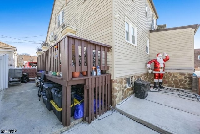 view of side of property with a patio area and a wooden deck