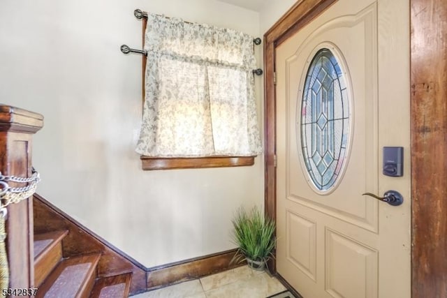 entrance foyer with tile patterned flooring, stairs, and baseboards