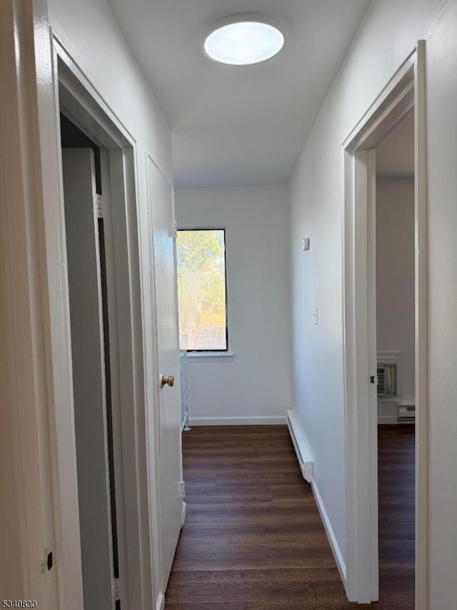 hall featuring dark wood-style flooring, a wall mounted AC, baseboards, and a baseboard radiator